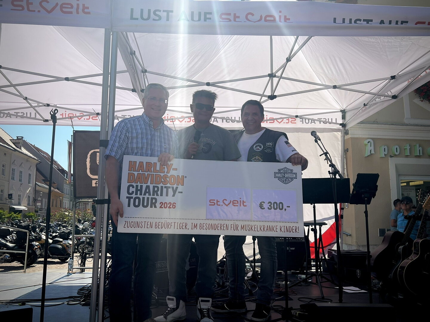 Harley-Davidson Charity-Tour 2026: Drei Männer mit Scheck über 300 Euro in St. Veit